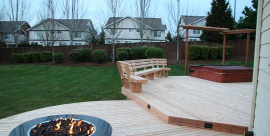 A wooden deck with a fire pit.