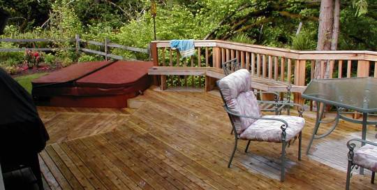A wooden deck with a hot tub.