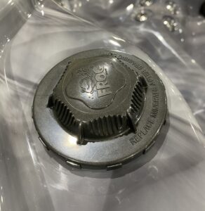 An image of a metal cap on a clear surface.