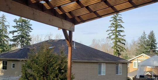 A wooden deck with a pergola over it.